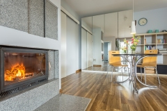 Modern living room with fireplace, table with chairs and wardrobe with wide mirror