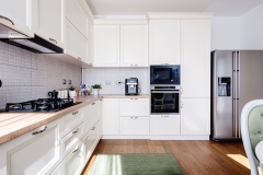 Modern kitchen interior with hardwood floors and wooden white creamy furniture