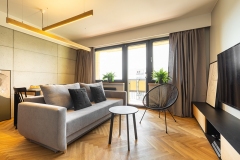 Urban style, cozy living room interior with industrial concrete walls, gray furniture and accessories and herringbone hardwood floor